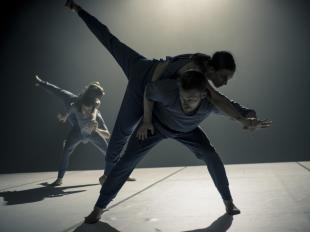 three dancers are silhouetted on stage