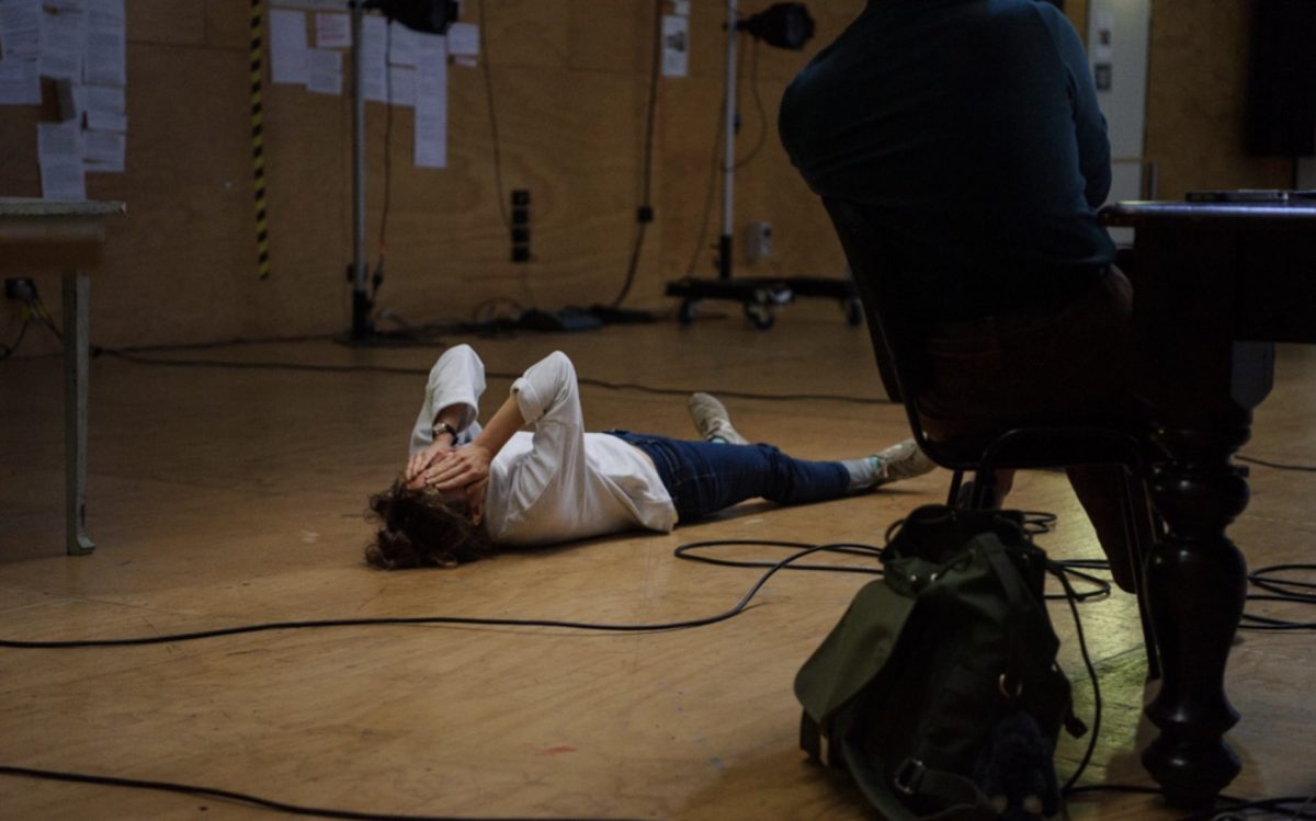 Woman laying on floor covering her face. Photo Sarah Walker