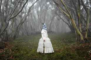 Woman in Australian bush with Victorian dress and rabbit headdress..
