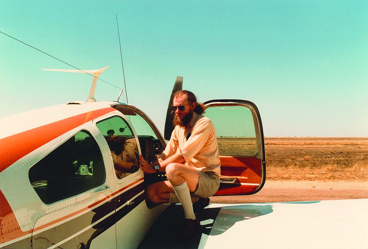 Man sits on wing of plane