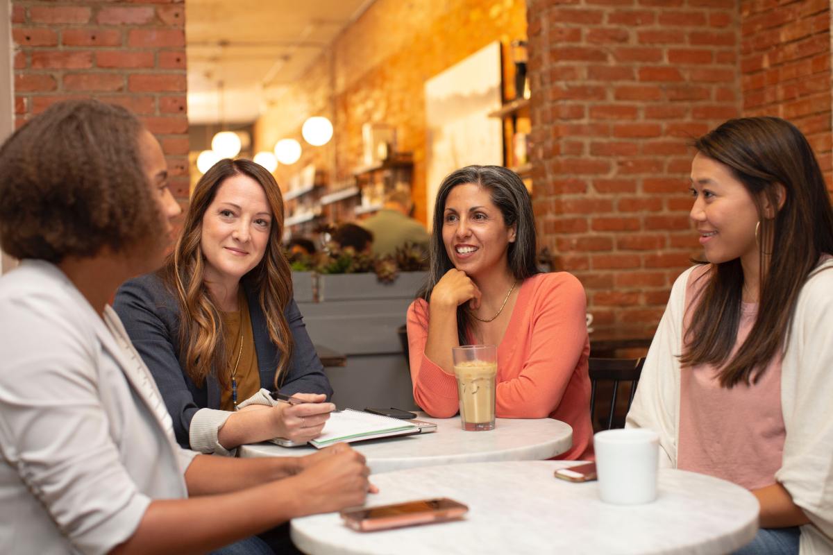 Four women talking in an office environment