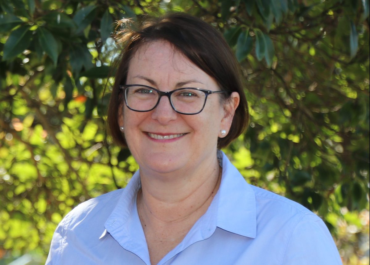 Susan Templeman MP smiles for the camera. She wears a blue shirt, glasses, and has brown hair.