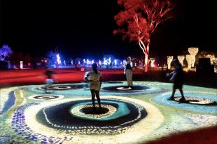 people walking around light festival of Aboriginal Art. Parrtjima