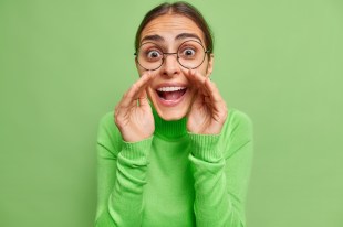 woman in green top shouting between hands