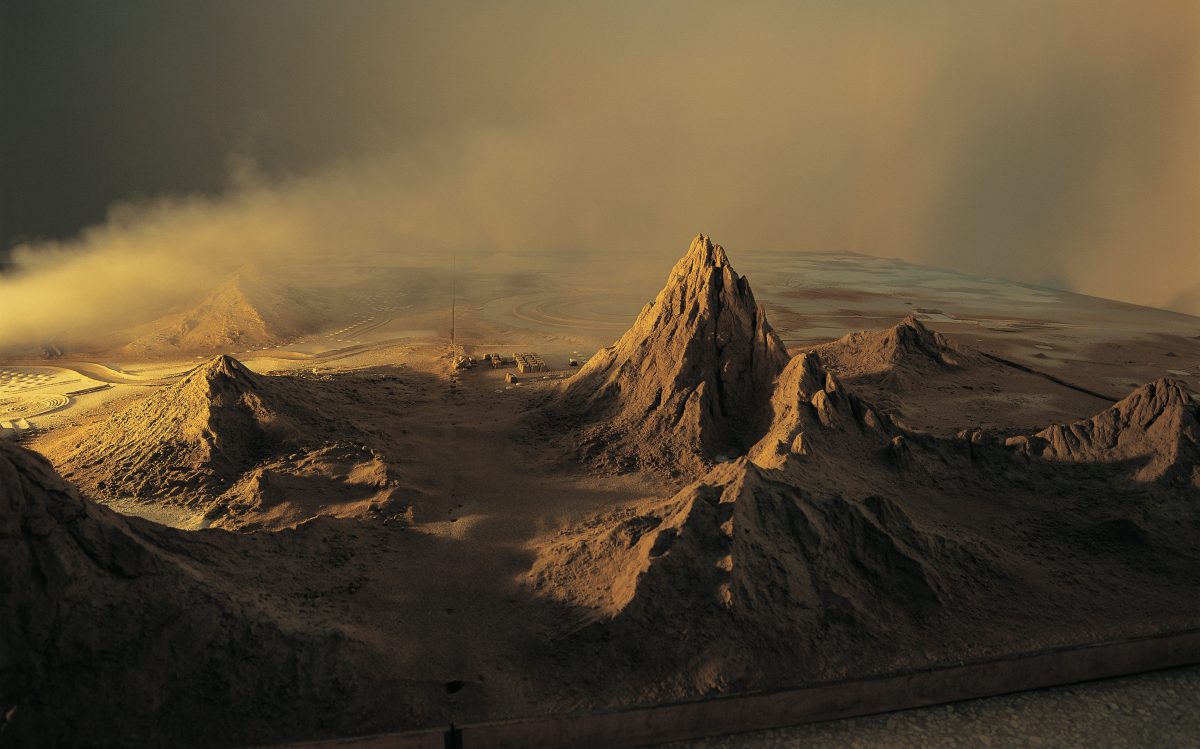 Yuan Shun, ‘Soft Landing’, 2018, on view as part of ‘A Blueprint for Ruins’ at White Rabbit Gallery. Image: Supplied. A model of a brown dusty landscape that feels otherworldly, made with wood, sand, lights, fog machine, stones and aluminium.