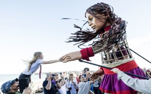 Giant street puppet with girl. Little Amal, Adelaide Festival.