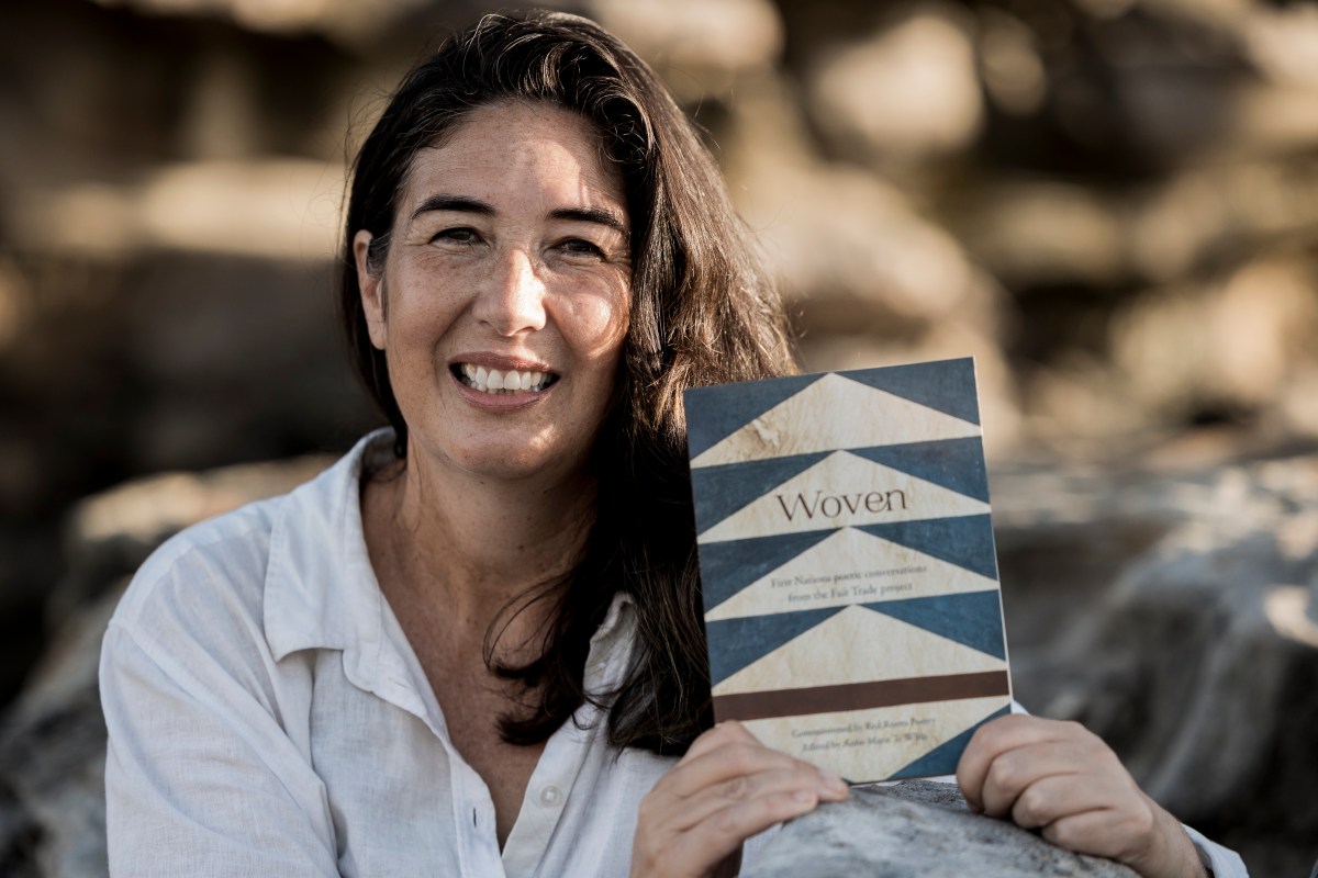 Anne-Marie Te Whiu holding a copy of Woven.