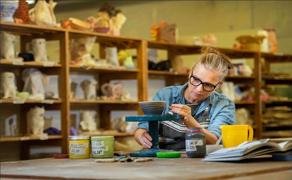 Woman working on pottery wheel