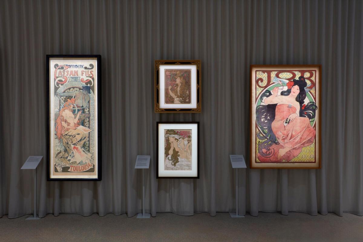 There are four iillustrations by the artist Alphonse Mucha. Two smaller pictures sit on top of each other and two bigger pictures are on either side.