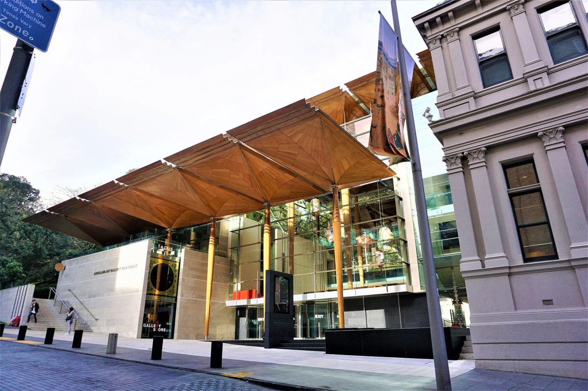 Exterior view of an art gallery with a timber roof and glass facade. Auckland Art Gallery.