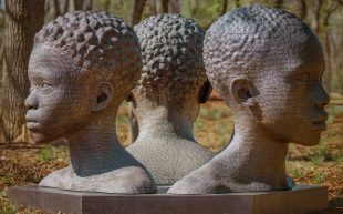 MTArt Agency Project in Alabama, US, the first sculpture park dedicated to addressing how slavery is depicted, featuring artist Rayvenn D Clark. Photo: Supplied. A large-scale sculpture of three busts of black figures, presumably of African descent.