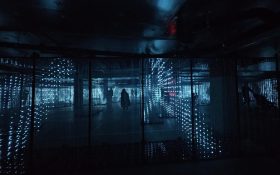 ‘Firelight Labyrinth’ underneath Marvel Stadium, as part of Firelight Festival. Photo: ArtsHub. A dark underground carpark space filled with volumetric displays of LED lights, glowing in light blue.