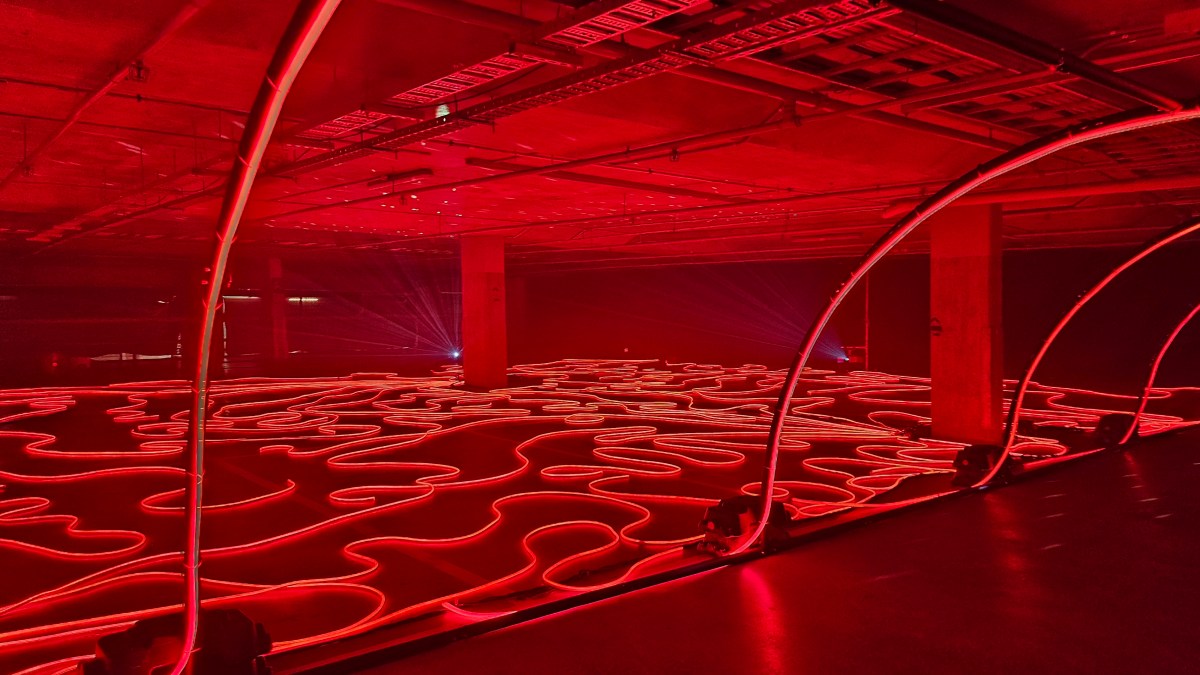 ‘Firelight Labyrinth’. Photo: ArtsHub. Red LED light tubes snaking through the underground carpark, illuminating the entire space. 