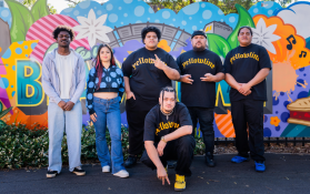 2024 Generations Western Sydney Music (Early Career) Fellowship recipients (L-R): FRIDAY*, Gemma Navarette and Yellowline. Photo: Create NSW. Recipients standing outside in front of a colourful mural.