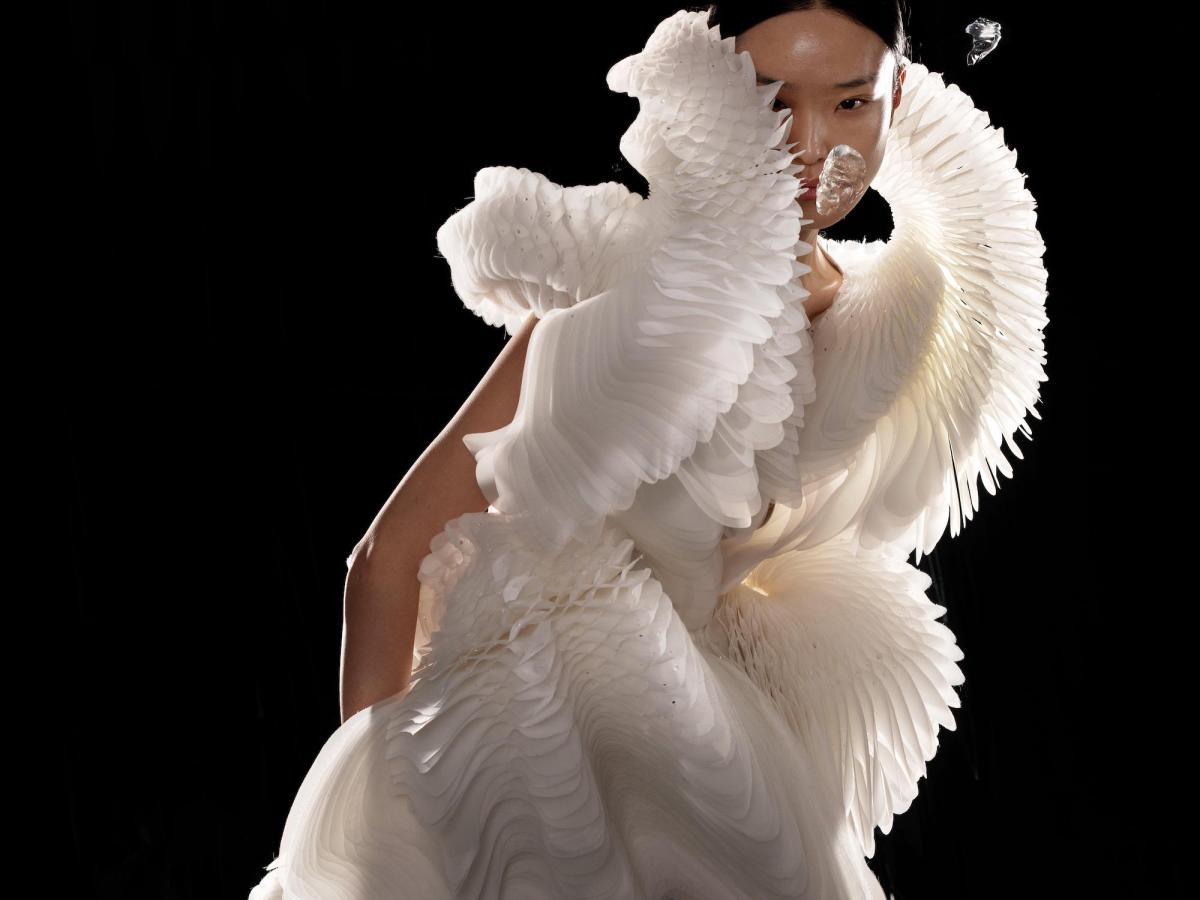 Asian woman wearing contemporary dress of flowing white fabric. Iris van Herpen.