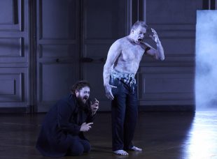 Two men on stage singing opera, one with white body paint as a ghost. Hamlet.