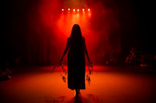 Shadow of a woman on a stage with dramatic red lighting. Yirramboi Festival.