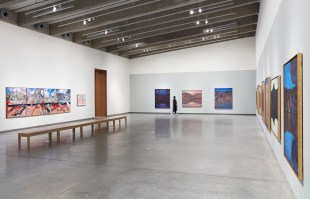 Gallery with cement floors and colour landscape paintings. Arthur Boyd.