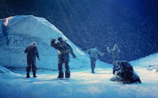Lighting designer Paul Jackson nominated in the 2024 APDG Awards for 'Do Not Go Gentle', Sydney Theatre Company. A stage set lit in blue light depicting a group of five people huddling and finding their way in a harsh snowy landscape.