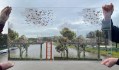 Drawing on sheet of glass being held up in front of landscape. Yarra River.