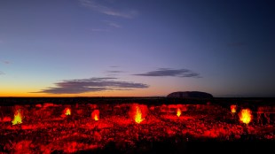 Red and orange light projection on to earth in Central Australia at dawn. Sunrise Journeys, Uluru