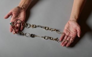 Jewellery chains by Belinda Newick to feature at Radiant Pavilion 2024. A metal chain with ring-like ornaments held between two hands.