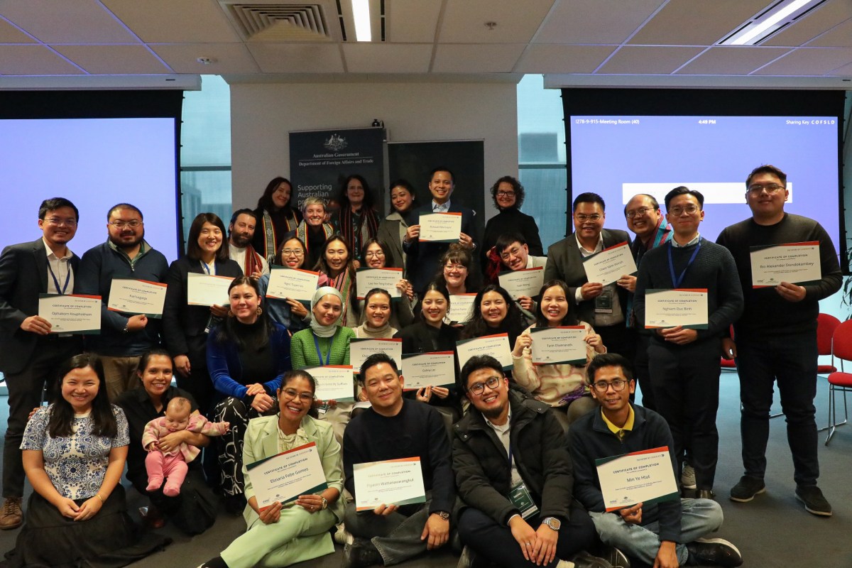 The Future of Leadership program cohort. A photo of a group of around 20 people each holding a certificate inside a room. They are all smiling at the camera. 