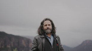 Man with long brown hair and beard in mountain landscape. Blue Mountains.