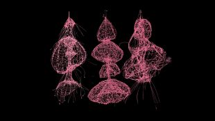 Iridescent pink web sculptures pictured hanging in a pitch black setting.