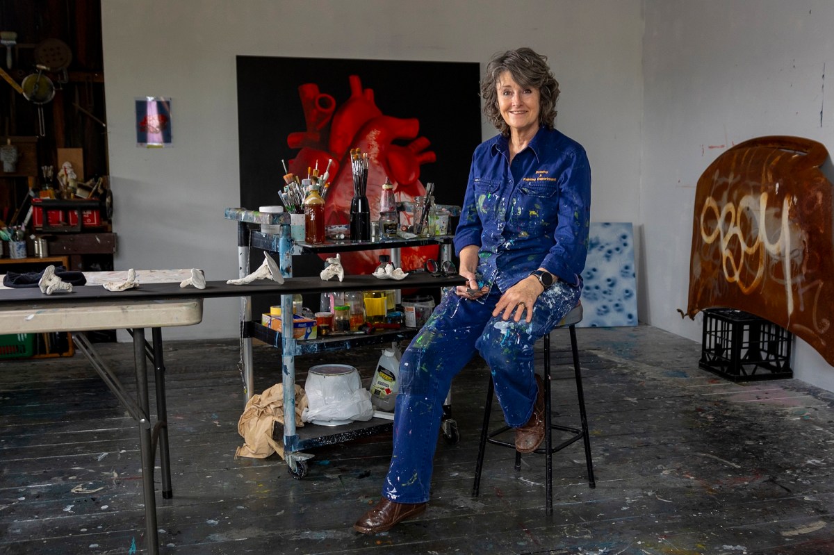 Female painter in blue overalls in studio setting. Meg Walch. Tasmania.