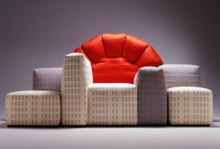 Lounge in the shape of a city skyline with a red sun cushion in the center. Design.