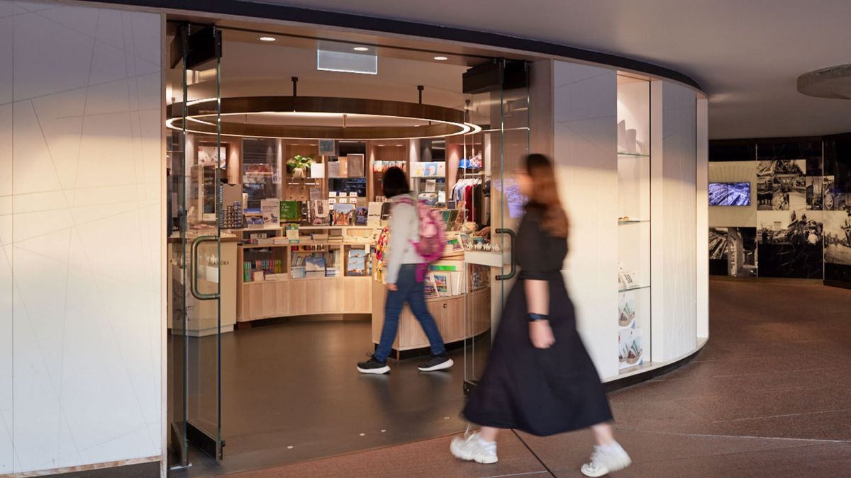 The Sydney Opera House Shop could soon be stocking your work thanks to the annual Uncovered retail program. The photo depicts a woman walking towards the door of the Sydney Opera House Shop, through which a range of retail objects can be glimpsed.