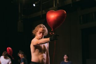 Artist Chris Dyke, performing with the signature Banksy heart balloon.