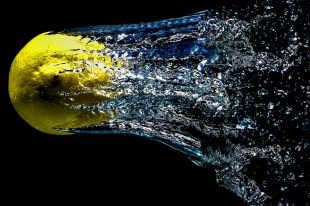 High speed image of a tennis ball with water trail. Cut-through content