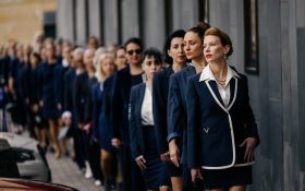 Kirsha Kaechele and supporters, Ladies Lounge Supreme Court of Tasmania Hearing. A group of more than 20 women wearing navy business suits lined up in single file, with Kirsha at the front.