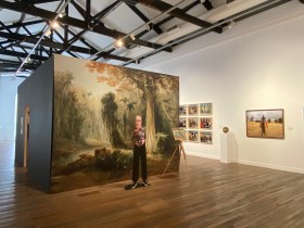 Cube structure covered with photographs and cut out of woman in gallery environment. Anne Zahalka