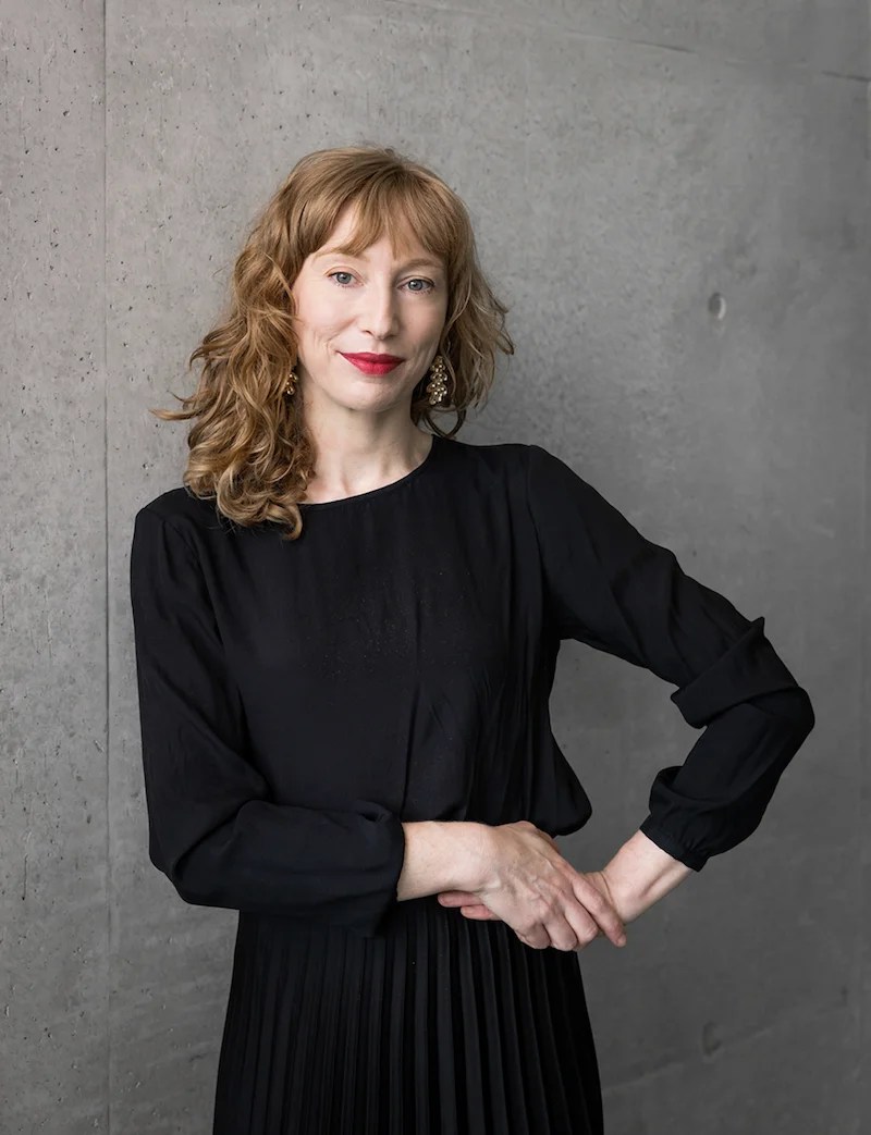 Young professional woman in black dress with ginger hair. Curator Meg Robson