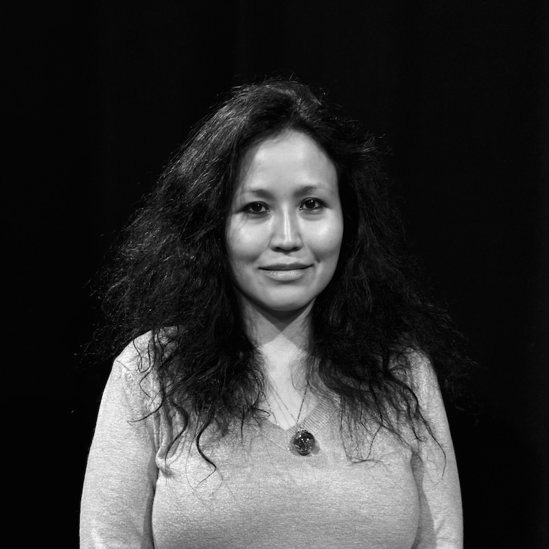 Black and white photo of young woman with long black hair. Curator Rachael Kiang