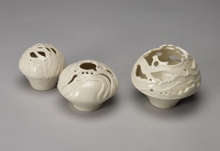 Three white porcelain vessels by WA artist Sandra Black, pictured against a grey background.