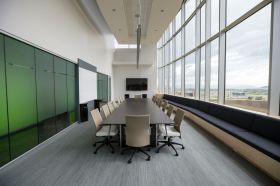 arts boards: an empty board meeting room with a central large table and 8 chairs.