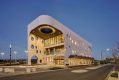 Façade of a building. Biyal-a Armstrong Creek Library. Its walls have circular windows.