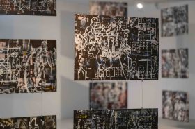 Artwork by Khaled Sabsabi hang from the ceilings. There is a video still on the left.