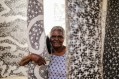 Artist Naminapu Maymuru-White at Buku-Larrŋgay Mulka Centre in Yirrkala. First Nations art exhibition presented by National Gallery of Victoria to open at National Gallery of Art, Washington DC. Photo of a senior Aboriginal woman among painted poles.