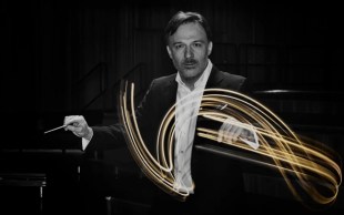 Black and white photo of QSO Chief Conductor Umberto Clerici waving his conductor baton. The swirls are depicted in yelllow.