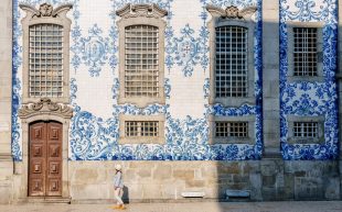 woman tourist viewing painted tiles on building in Portugal. Cultural tourism