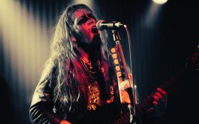 The inaugural Essence Festival. Photo of a heavy metal singer on stage, cast in red light.