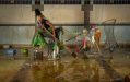 Karla Dickens, '#2 Rise and Fall', Inkjet prints. Recipient of the 2024 Windmill Trust Scholarship. A brown-skinned woman in a witchy outfit sitting on a shopping trolley filled with plastic waste as teh ground around them is flooded.