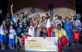 DanceRites 2024 Overall Winner, Mackay Torres Strait Islander Cultural Group. A group of Torres Strait Islander dancers cheering with their hands held high as they hold a $22,000 cheque.