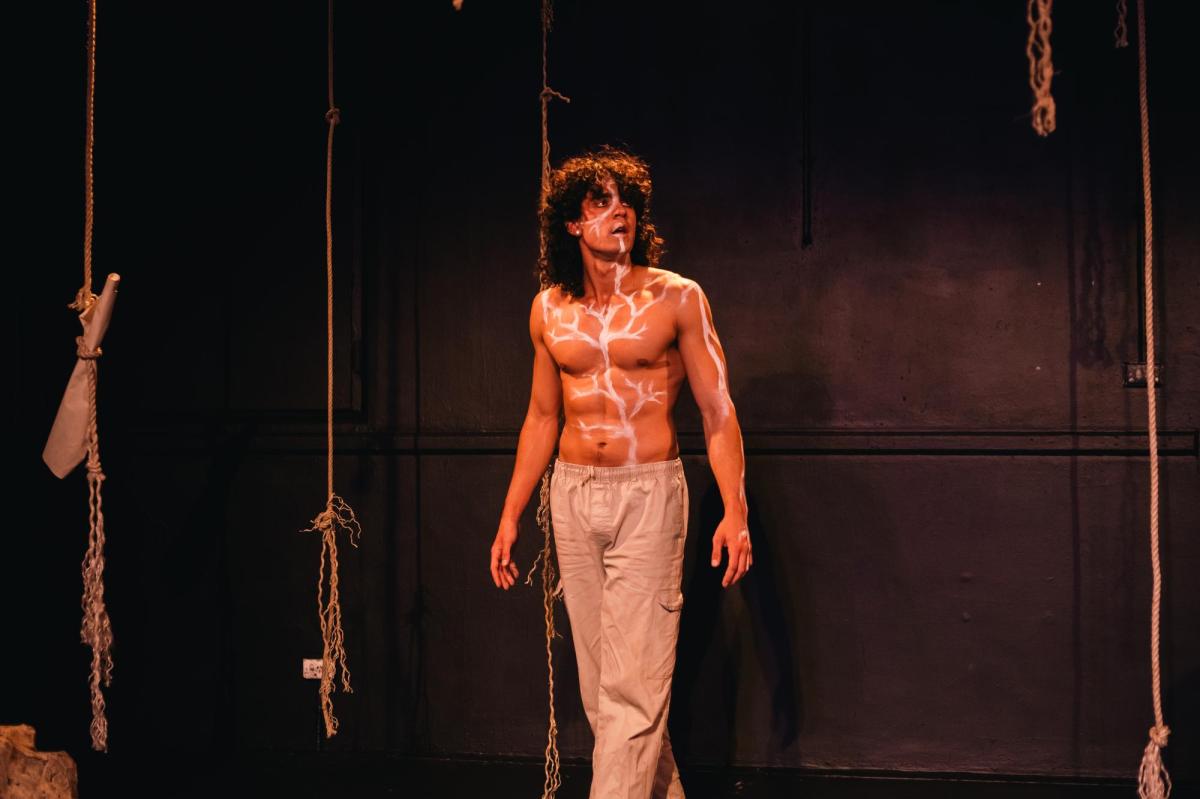 A young man bare-chested with a painting of tree branches on his torso in 'Ask'.