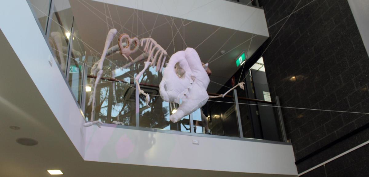 A fabric and skeleton of a dinosuar arranged on a balustrade by artist Mark du Potier.